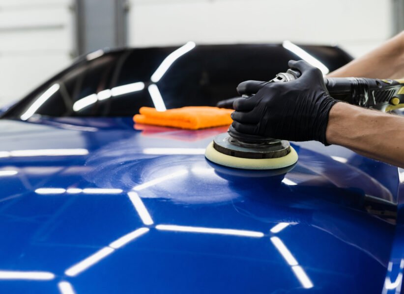 Car polishing with orbital polisher for remove scratches. Worker of detailing auto service making final polishing for car