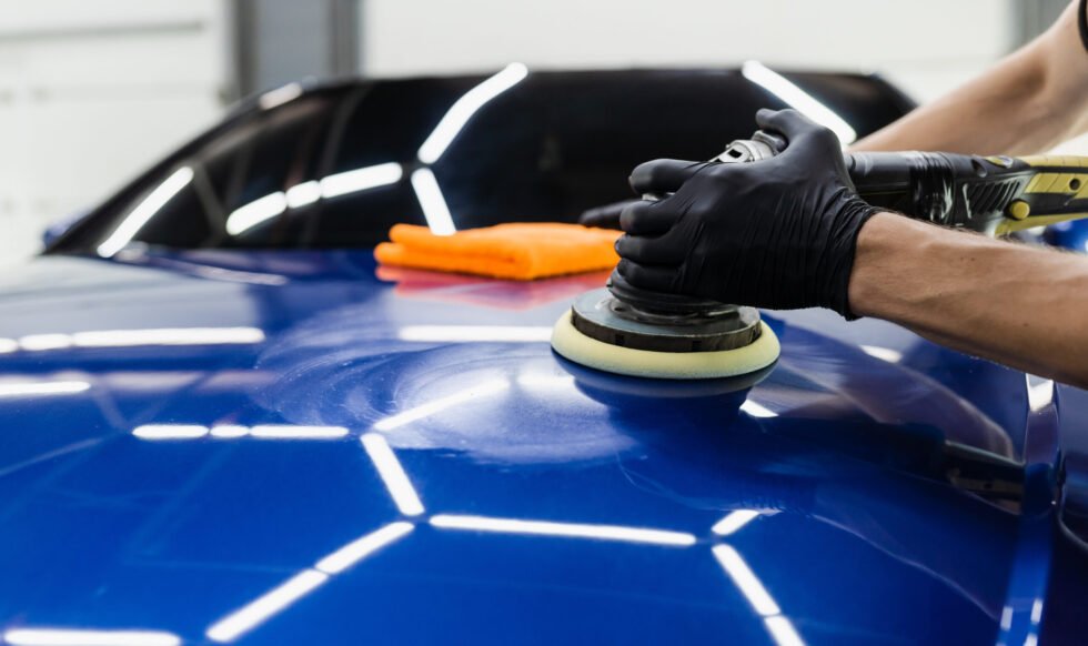 Car polishing with orbital polisher for remove scratches. Worker of detailing auto service making final polishing for car