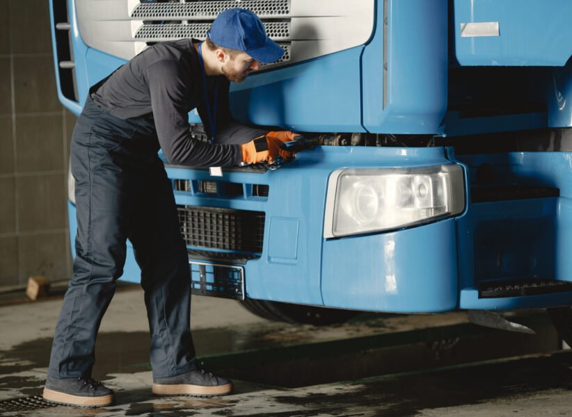 A young worker checks the wheel. Truck malfunction. Service work.
